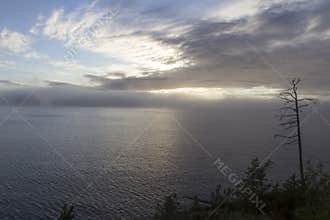 The water surface of the lake smoothly passing in the fog into the sky