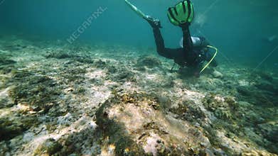Group of divers prepares for diving in shallow ocean