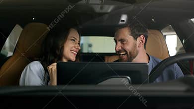 Happy couple celebrate buying new car sitting inside salon achieve gesture Caucasian family boyfriend girlfriend wife