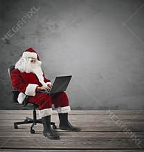 Modern Santa Claus with laptop