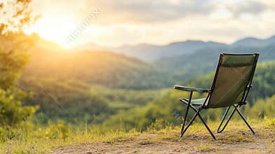 Folding chair placed on a hill enjoying beautiful sunset over mountain valley, concept of freedom, relax and travel