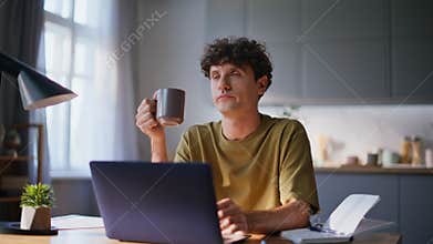 Overworked man sipping beverage at workplace closeup. Pensive author drinking