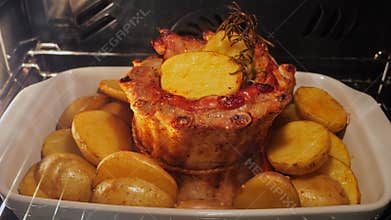 Pork ribs with potatoes baked in the oven, process of cooking. Time lapse.