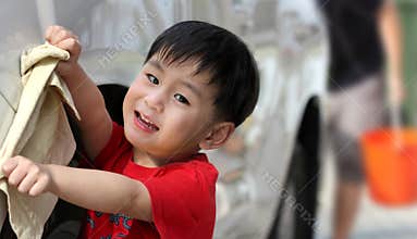 Happy boy washing car
