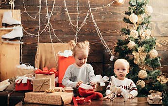 Winter kids. Christmas card. Cute little kids celebrating Christmas. Joyful baby looking at camera in christmas at home