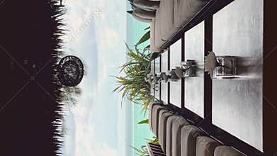 Few tables in row in restaurant on a beach club at sunny day, lounge chairs, sofas