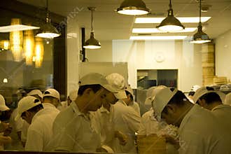 Busy chefs in chinese restaurant kitchen