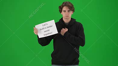 A male activist points to a placard in his hand that reads Let&#x27;s Build a Better World Together. The man holding the
