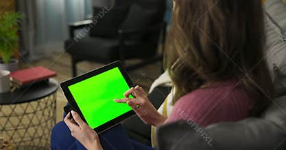 Woman could be aspiring chef, following online cooking tutorial experimenting with new recipes. The green mockup screen