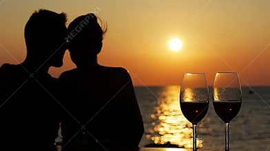 Close-up photo of a loving young couple during date on the beach at sunset.