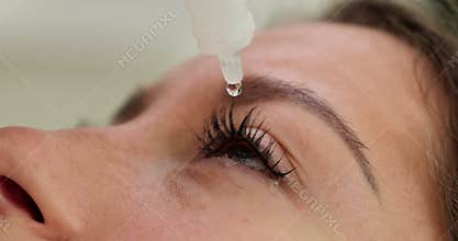 Closeup view of woman using eye drops