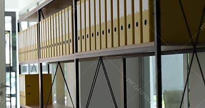Many yellow identical folders were added to shelf in office