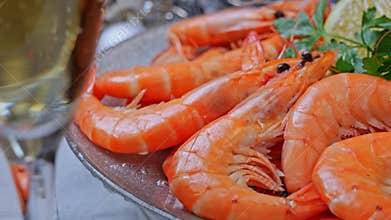 Cooked shrimps on a plate rotating, Christmas New Year decoration, pour champagne into a glass. Close up