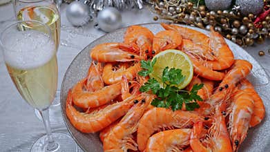 Cooked shrimps on a plate rotating, Christmas New Year decoration, pour champagne into a glass. Close up