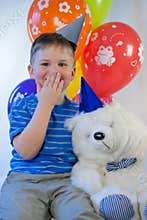 Happy boy with a teddy bear in the party