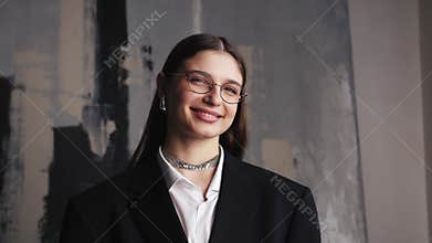 Portrait of happy beautiful caucasian young woman creative employee looking at camera and smiling in modern office