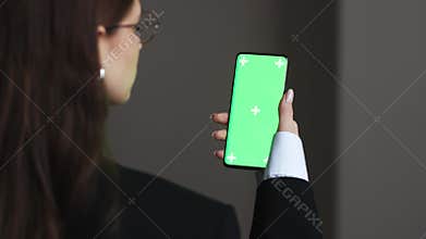 Woman is Holding Smartphone with Green Screen at home or office. Using Smartphone Watching Green Screen Top View