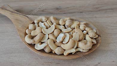 Zooming at the cashew nuts on a wooden dish. Healthy snacks