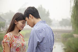Affectionate Couple Touching Heads By a Canal