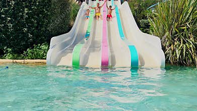 Fun water slide descent of father with kids during summer trip