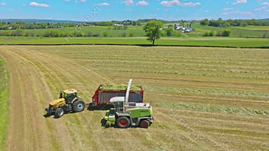Harvest Dance: Tractors Bale Hay in Golden Fields with azure skies