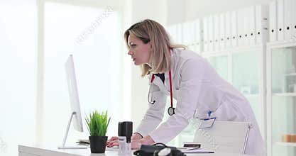 Doctor studying information on computer and in patient medical history in clinic 4k movie slow motion