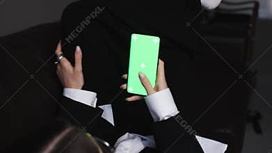Woman hands watching chromakey mobile phone laying home sofa closeup. Unrecognized lady tapping green screen resting