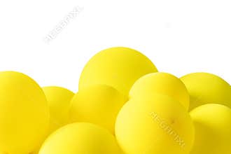 A bunch of yellow balloons floating on a white isolated background. The balloons are of similar size