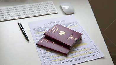 Close up of a visa application document with two German passports on table