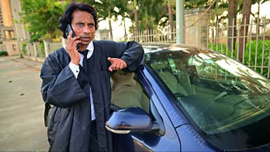 Lawyer standing next to car talking on phone