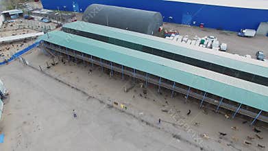 Dog shelter near storage buildings at autumn day.