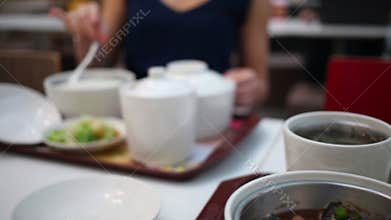 Hot meat, rice and soup in pots, woman opens pots