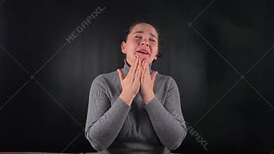A woman interacting with an object isolated on the black backdrop
