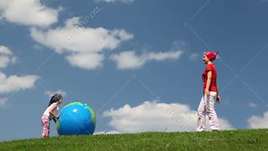 mother and daughter rolling inflatable ball to