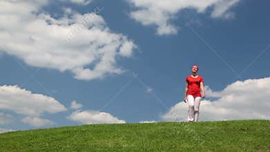 lady walking on meadow towards to camera, passinng