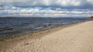 autumn nature scene, sandy bank of river, sky with