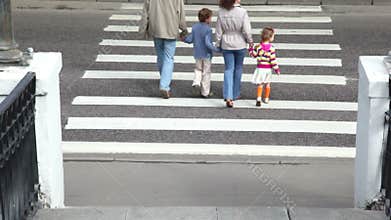Family goes by pedestrian crossing road, parents