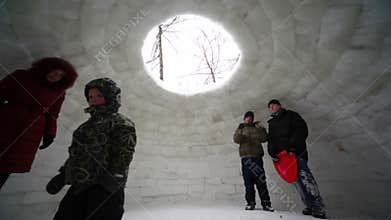 Woman and few kids stand inside ice house, trees