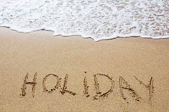 Holiday written in sand