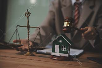 Real Estate Law, Home Insurance, property Tax, Auction and Bidding concepts. small toy house model with gavel justice hammer on