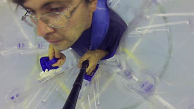 Man with selfie stick climbs in big ball for