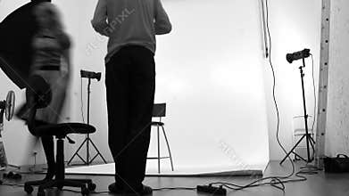 Photographer and model in studio. In black and
