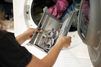 Housewife cleanup lints and dirt from tumble dryer filter