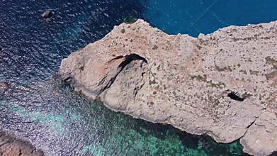 Natural windows in the rocks, Comino Island Malta, Close up revealing drone shot