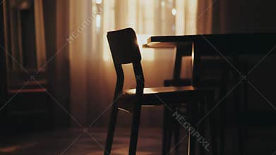 Empty chair in dim room with warm light