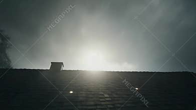 Roof and chimney in dark misty morning light