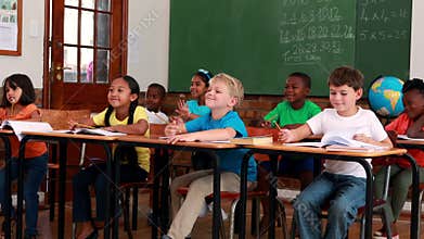 Pupils listening and writing during class