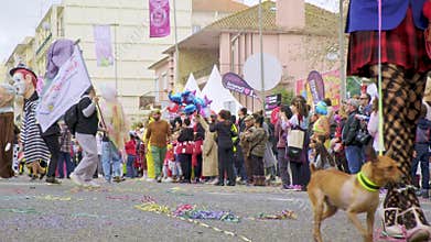 Man dressed in burlesque female clothes and giant big head dolls walking at carnival in Torres Vedras, Portugal