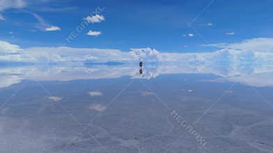 Aerial view of a serene salt flat in Bolivia, capturing the vastness of the landscape and the striking reflection of the sky