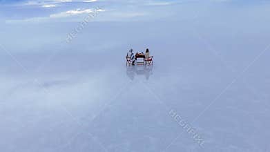 Aerial view of a serene picnic on the expansive Salar de Uyuni salt flats in Bolivia, capturing the unique reflection of clouds on
